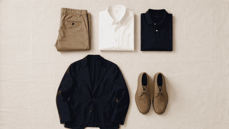 five essential men's business casual pieces including chinos oxford shirt polo blazer and leather shoes displayed as flat lay