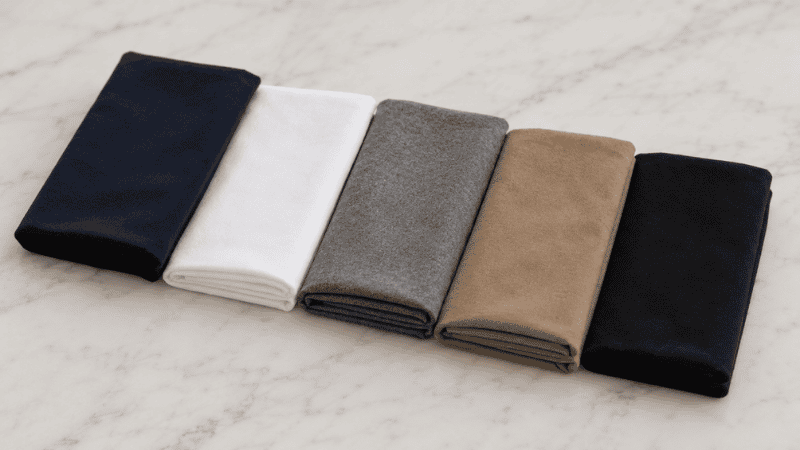 men's capsule wardrobe neutral color palette swatches showing navy white grey khaki and black foundation colors