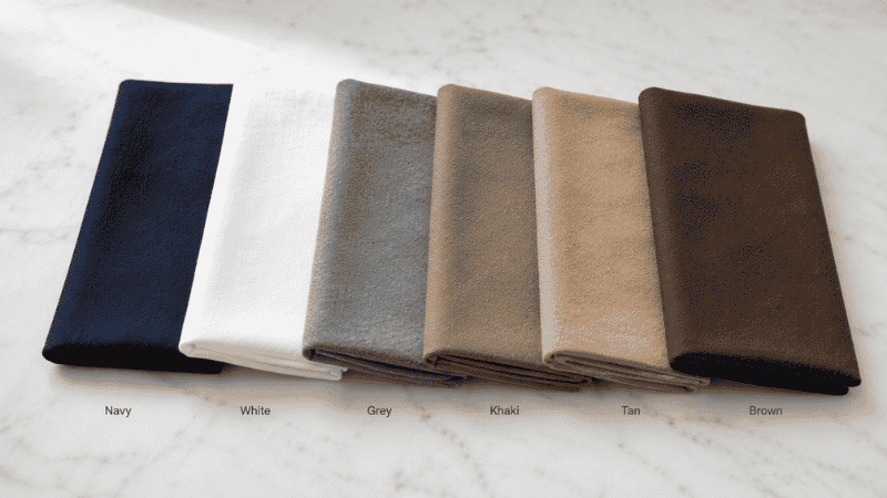 men's wardrobe neutral color palette showing navy white grey khaki tan and brown fabric swatches for essential wardrobe building