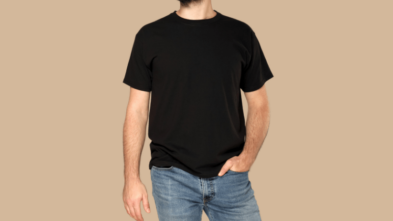 A man wearing a modern smart-casual outfit consisting of a tailored navy blazer paired with a high-quality grey t-shirt and slim-fit dark denim jeans, demonstrating versatile wardrobe styling.