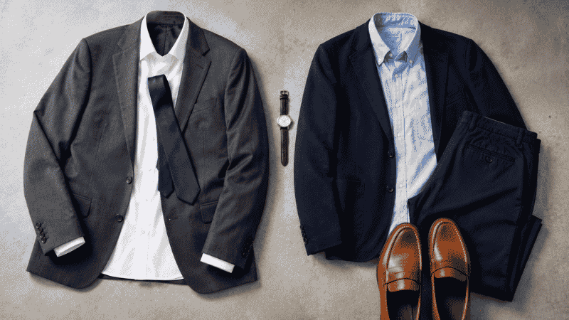 men's job interview outfit guide flat lay showing charcoal suit navy blazer oxford shirt chinos and leather shoes for different company types