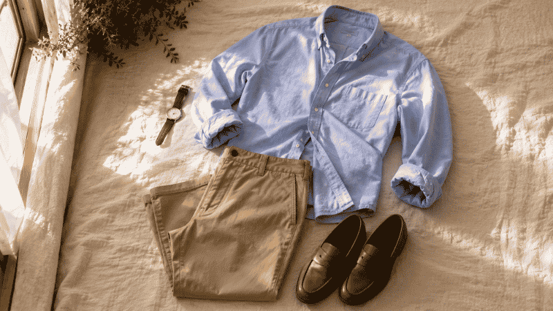 men's casual brunch outfit flat lay with light blue oxford shirt khaki chinos and tan leather loafers for weekend lunch